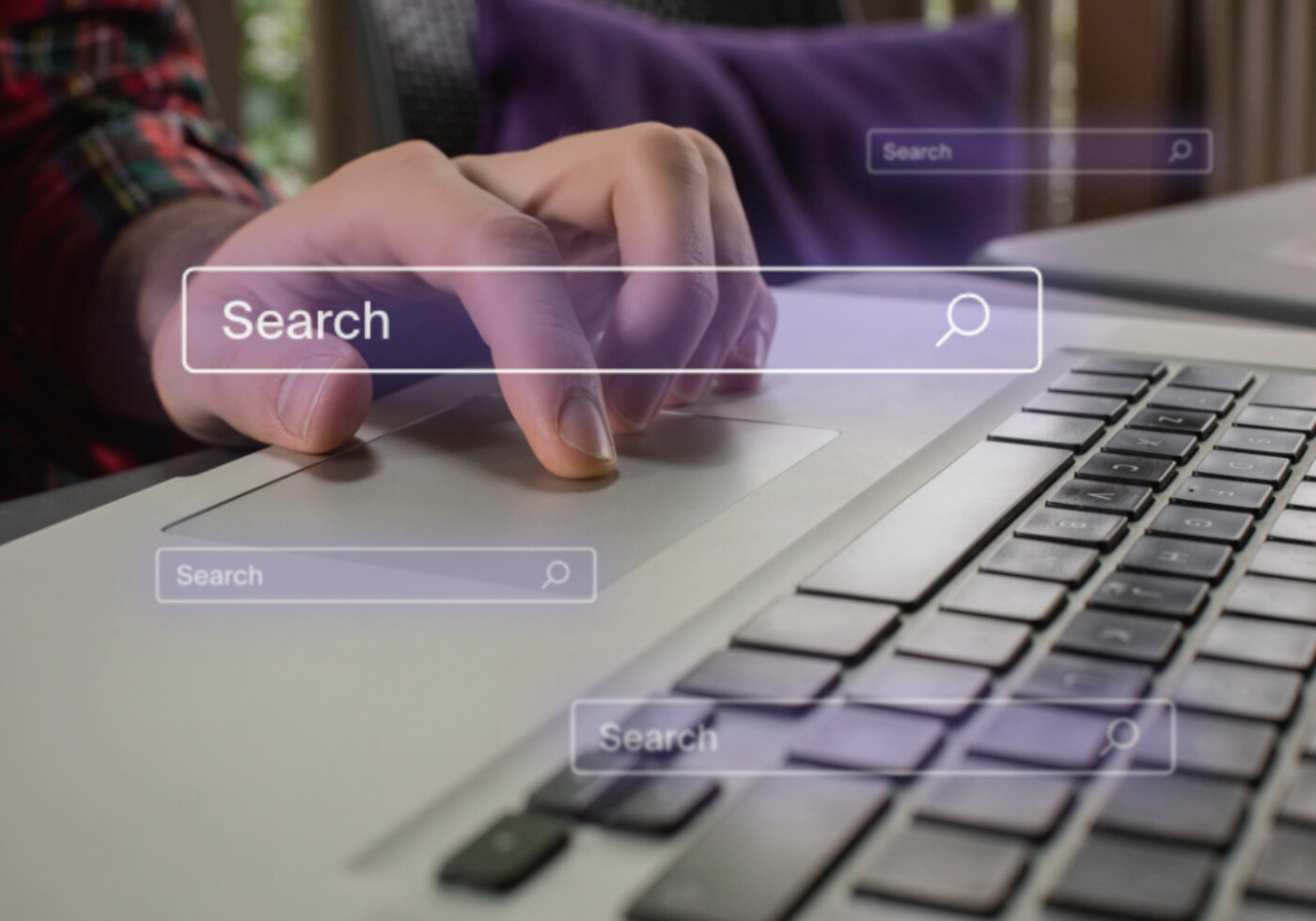 Hand on the laptop using the keyboard with search boxes overlying