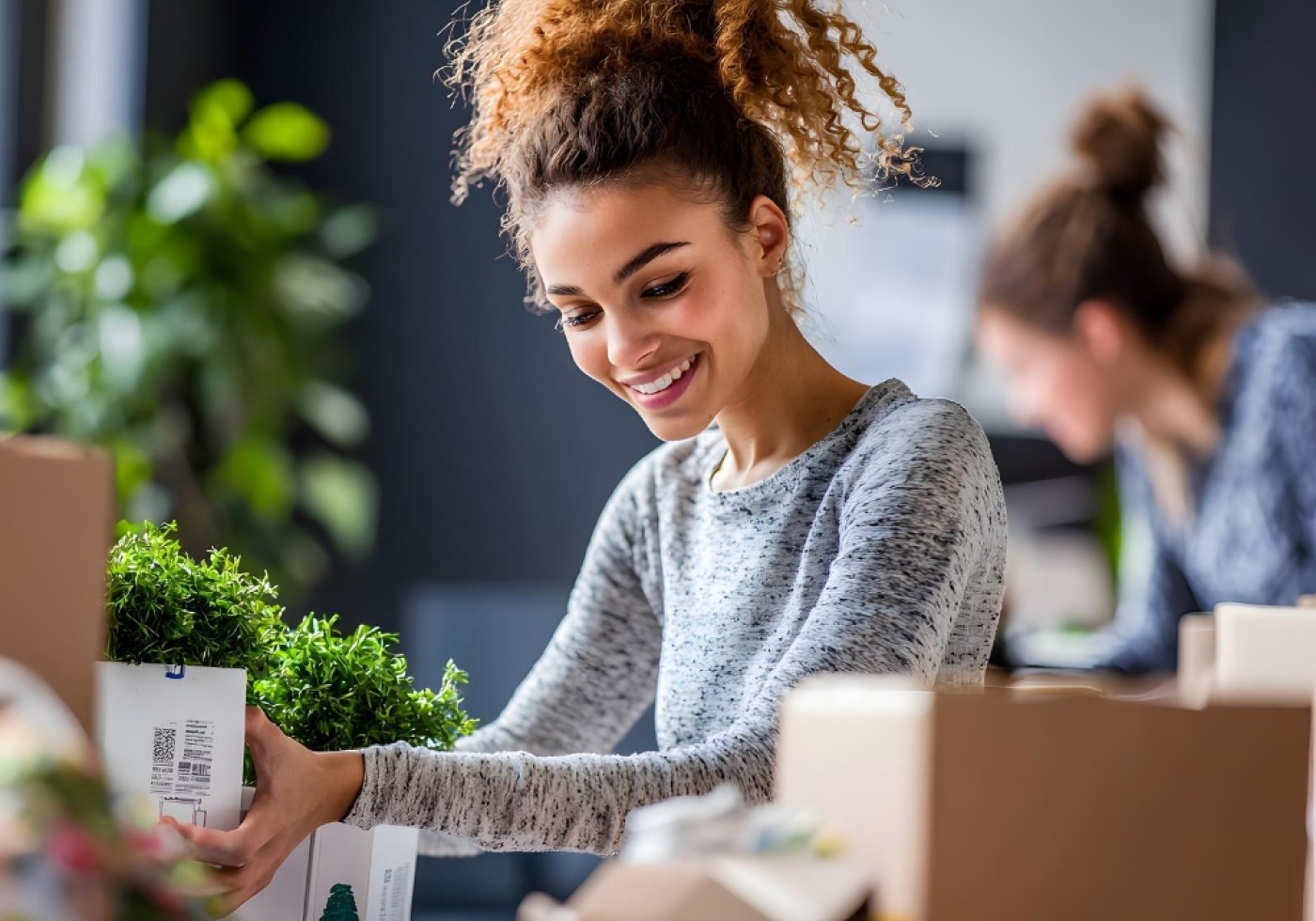 Smiling woman packing plants in boxes for shipping.