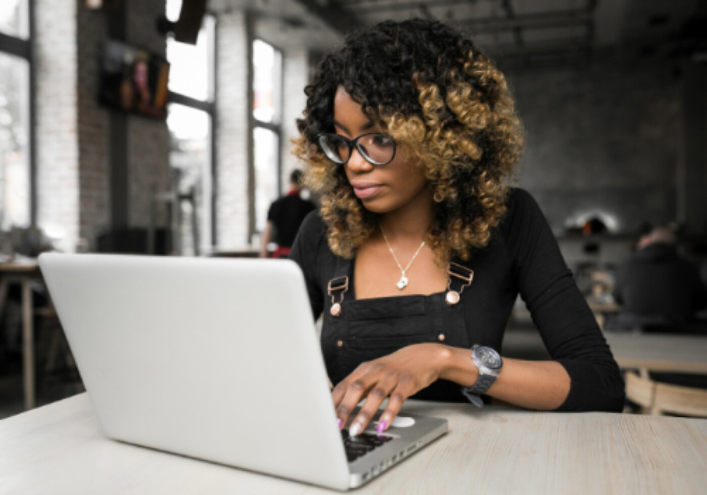 Woman working on a laptop in a modern workspace.